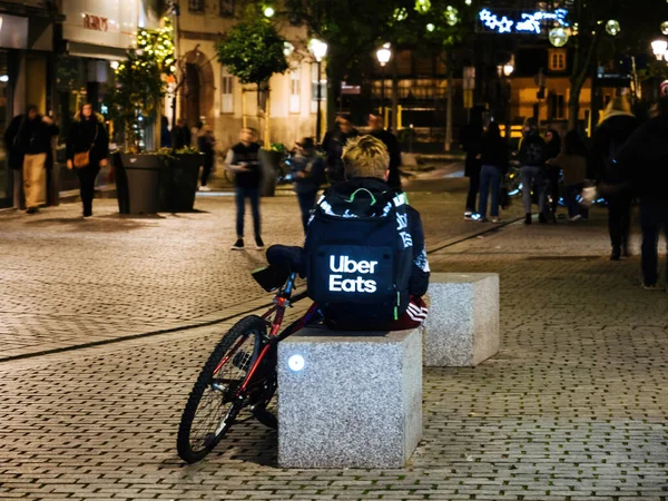 孤独的uber吃着应用驱动程序交付坐在石头城市家具上的年轻人 — 图库照片