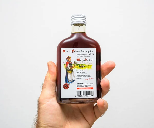 Männliche Hand hält Flasche mit Maria Treben Pflanzenbalsam-Bitter schwedentropfen — Stockfoto