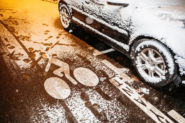 Carril de bicicletas cubierto de nieve durante la noche al lado del coche aparcado y el pago traducido como aparcamiento de pago —  Fotos de Stock