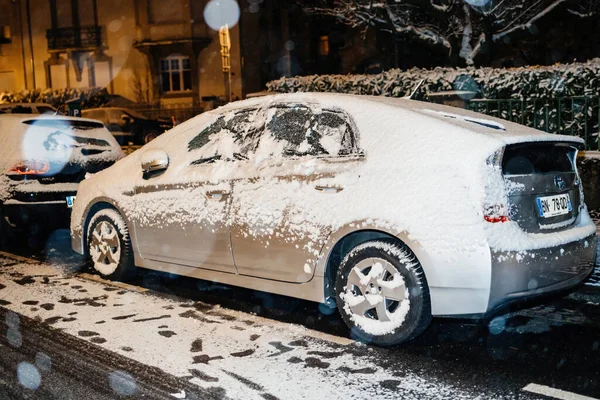 Bedeckt mit Schnee Auto silbernen Toyota Yaris Hybrid-Elektroauto auf der Französisch Straße in der Innenstadt von Straßburg — Stockfoto