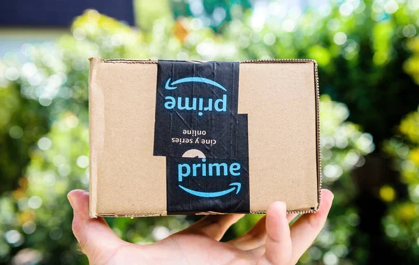 POV persönliche Perspektive männliche Hand hält Amazon Prime Karton-Paket Karton-Box mit kostenloser und schneller Lieferung Aufkleber — Stockfoto