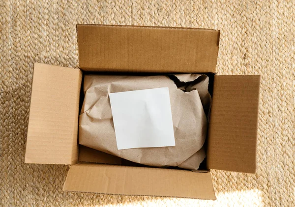 Bovenaanzicht van nieuwe pakketbezorging unboxing op vloer met wit papier — Stockfoto