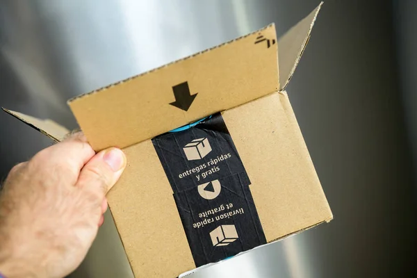 POV perspectiva personal mano masculina sosteniendo Amazon paquete de cartón caja de cartón con pegatina de entrega gratuita y rápida — Foto de Stock