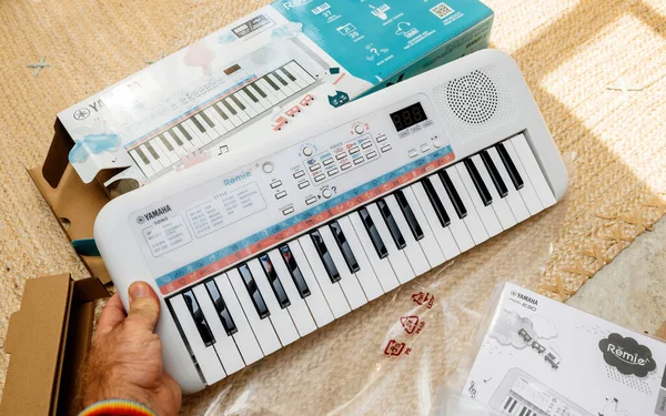 POV male hand unboxing new Yamaha Remie digital keyboard PSS-E30 for kids — Stock Photo, Image