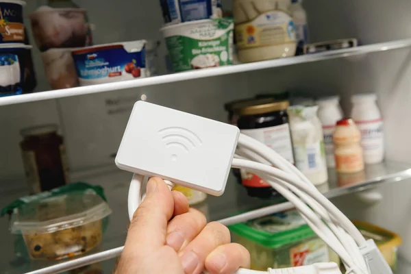 Buzdolabı kapısını aç, erkek eli modern buzdolabı için yeni Wifi dongle. — Stok fotoğraf