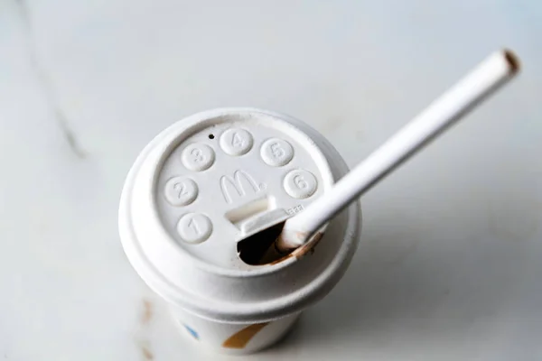 White plastic cup with McDonalds logotype on it and drinking straw — Stock Photo, Image