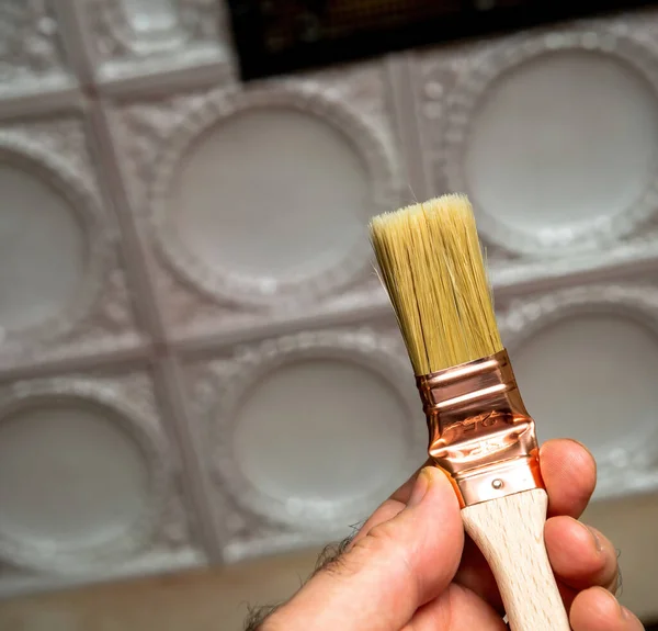 Erkek el ev dekorasyonu için yeni fırça tutuyor. — Stok fotoğraf