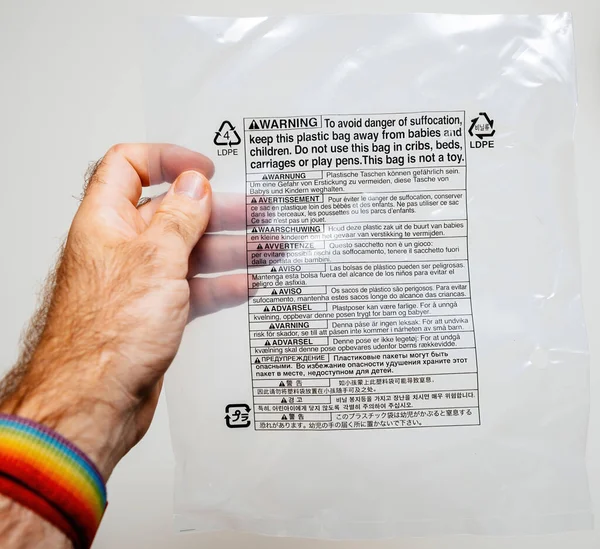 Пластикова рука з попередженням, щоб уникнути небезпеки задухи утримуватися подалі від дітей. — стокове фото