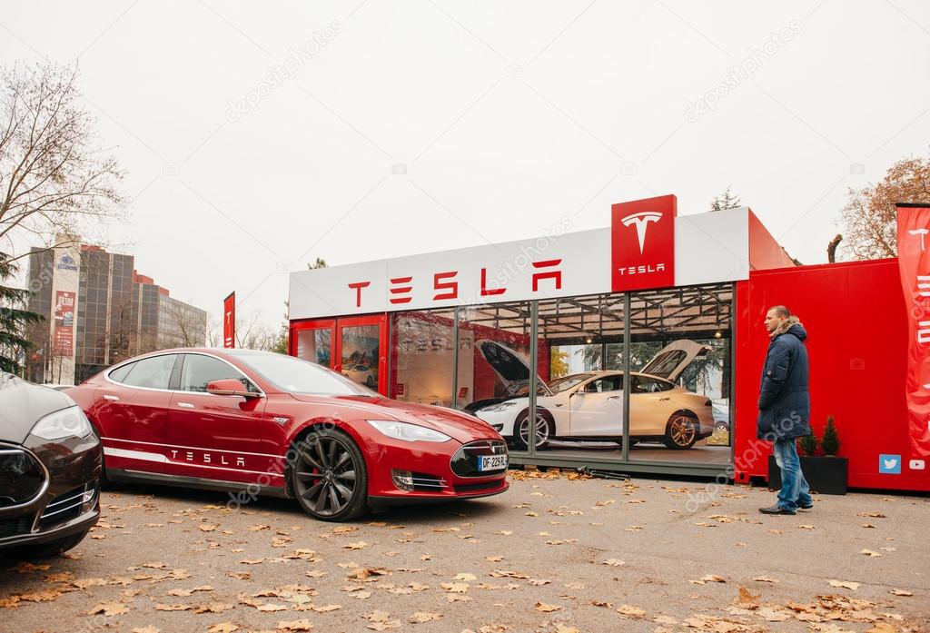 PARIS, FRANCE - NOVEMBER 29: Customer admiring new Tesla Model S at showroom  in Paris, France. Tesla is an American company that designs, manufactures, and sells electric cars