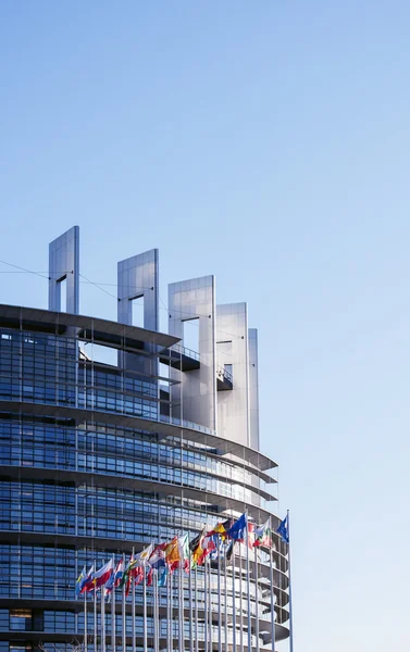 Parlamento Europeo en un día claro con todas las banderas de la UE — Foto de Stock