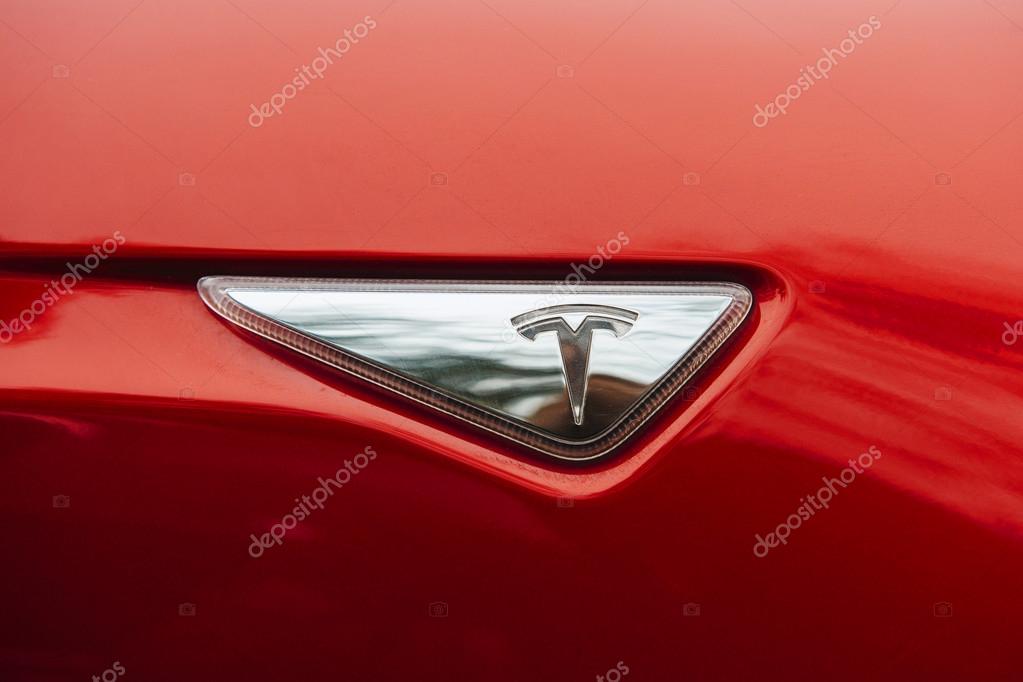 PARIS, FRANCE - NOVEMBER 29: Tesla brand signage of a red environmentally friendly car. Tesla is an American company that designs, manufactures, and sells electric cars
