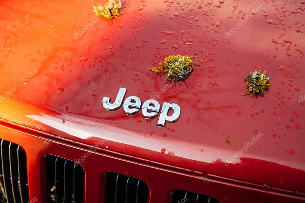 STUTTGART, GERMANY - CIRCA 2015: Jeep Motors car logotype after exploration adventure travel with moss plant on the car hood. The Jeep became the primary light 4-wheel-drive vehicle of the United States Army and the Allies during World War II, as wel