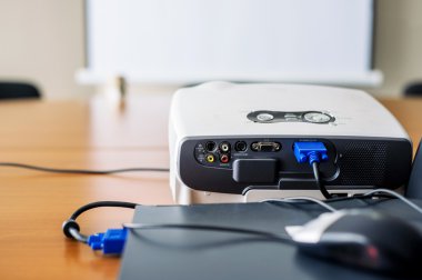 Sunum odası içinde laptop bağlı projektör