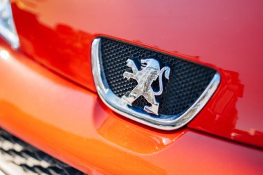 Peugeot logosu bir kırmızı araba