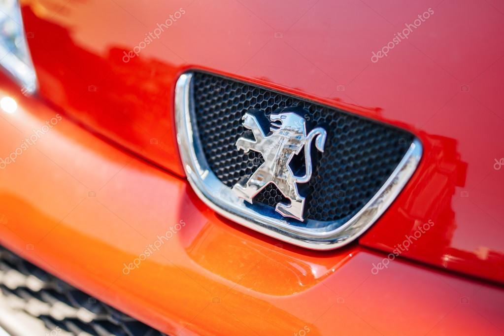 PARIS, FRANCE - APRIL 18, 2014: Peugeot lion logo on a red sport car. Peugeot is a French car brand, part of PSA Peugeot Citroen. In 2013, Peugeot ranked at the second lowest average CO2 emissions among generalist brands in Europe, with 114.9g CO2km