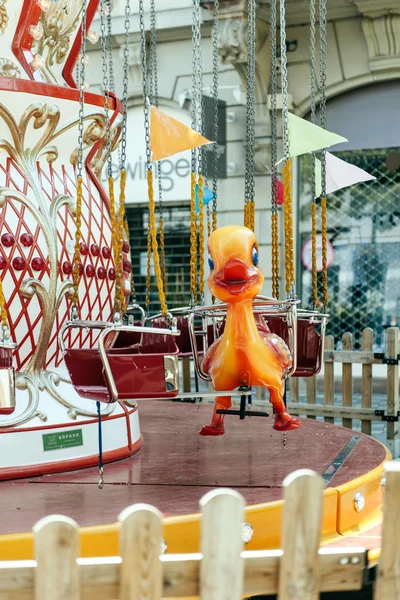 Duck toy in the seat of a colorful Merry Go Round — Stock Photo, Image