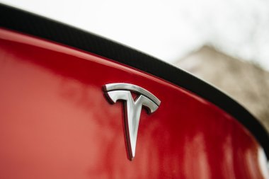 Tesla Motors logo on a red car. clipart