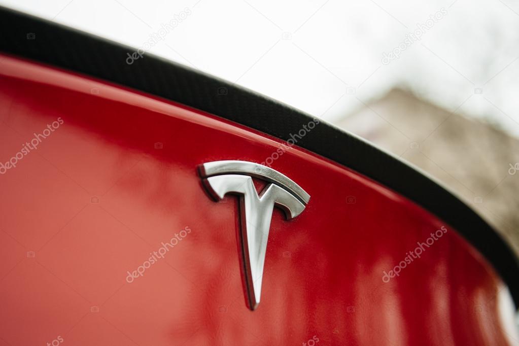 PARIS, FRANCE - NOVEMBER 29: Tesla Motors logo on a red car. Tesla is an American company that designs, manufactures, and sells electric cars