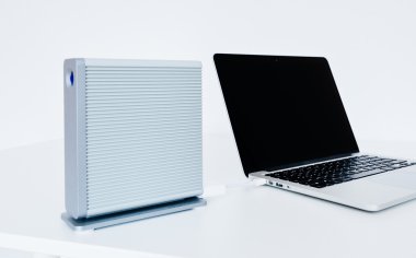 Modern laptop computer with external hard disk drive connected t clipart