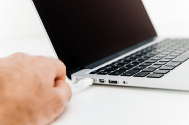 Hand connectiong thudnerbolt cable to modern laptop compute