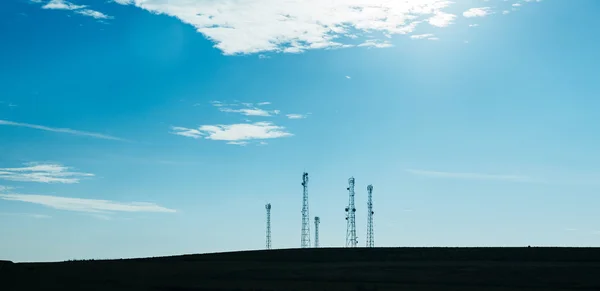 Beş telekomünikasyon direk Tv antenleri mavi gökyüzü ile — Stok fotoğraf