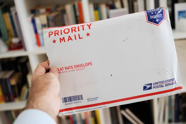 USPS Estados Unidos Servicio Postal Sobre de paquete en las manos del hombre — Foto de Stock