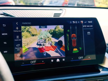 Rastatt, Almanya - 29 Nisan 2025: Arka park kamerası ve römork modu görüntüsünü gösteren elektrikli BMW iX gösterimi ekran ekranında yeşil ve park destek arayüzü yüklü çekici römorku