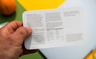 Paris, Fransa - 13 Mart 2025: Hollanda 'da yazılmış MacBook Air paketinde yer alan güvenlik ve garanti bilgi kartına sahip bir kişinin yakın görüntüsü