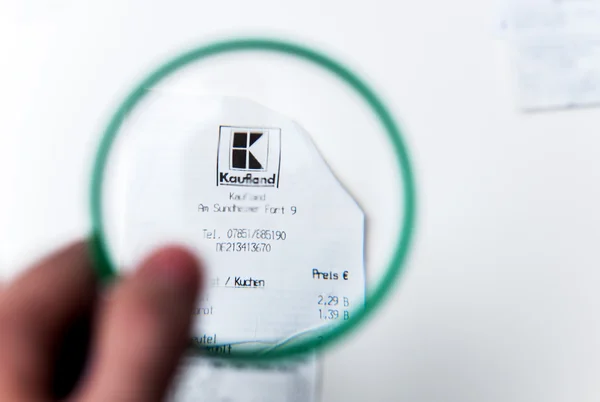 Kaufland receipt seen through magnifying glass — Stock Photo, Image