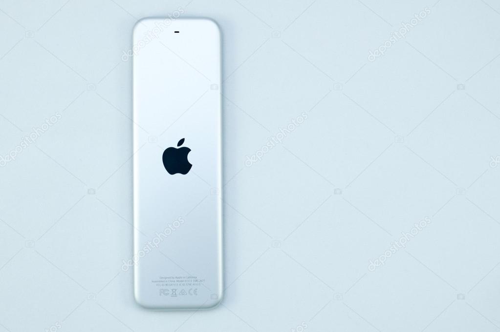 PARIS, FRANCE - NOV 10, 2015: Apple logo on the back of the New Apple TV media streaming  player microconsole by Apple Computers futuristic touch remote swipe-to-select with integrated Siri and motion sensor on pure blue technological backgroun