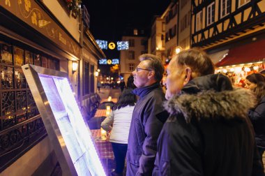 People reading Christmas menu in front of the restaurant