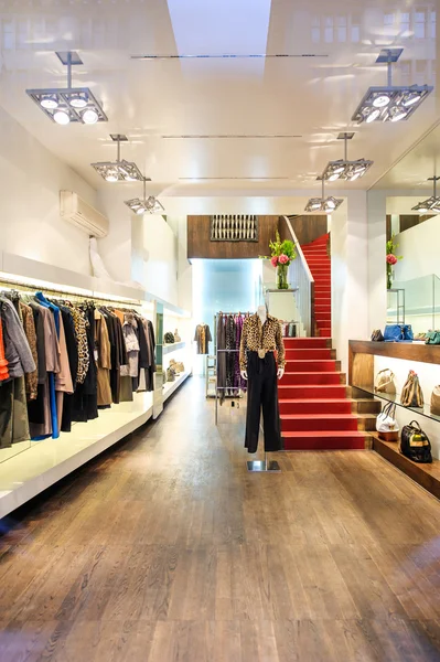 Interior de uma loja de boutique com vestido de mulheres de luxo na moda — Fotografia de Stock