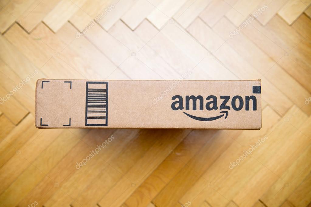 PARIS, FRANCE - JAN 28, 2016: Amazon logotype printed on cardboard box side seen from above on a wooden floor Amazon is the an American electronic e-commerce company