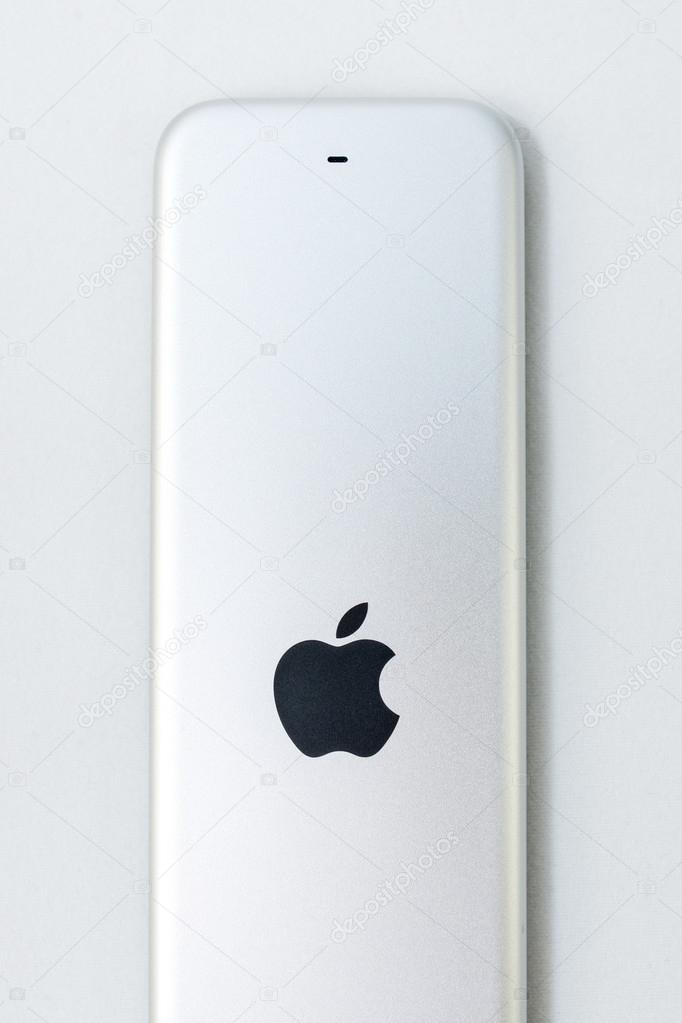 PARIS, FRANCE - NOV 10, 2015: Apple logo on the back of the New Apple TV media streaming  player microconsole by Apple Computers futuristic touch remote swipe-to-select with integrated Siri and motion sensor on pure blue technological backgroun