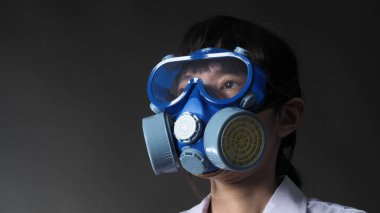 Kimyasal koruyucu maskeli ve koruyucu gözlüklü Asyalı kadın doktor. Doktor üniforması ve yerine konulabilir yarım maske filtre solunum cihazı. Kadın bilim adamı güvenlik maskesi
