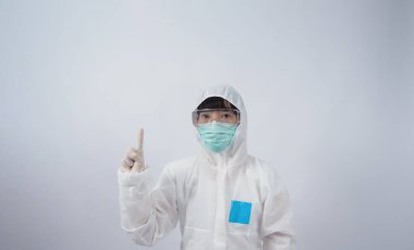 Doktor Jest. PPE kostümlü Asyalı kadın doktor ya da kişisel koruma jesti ve işaret. Beyaz plastik eldivenler. Salgın koronavirüsü korumak için gözlük ve yeşil N95 maskesi..