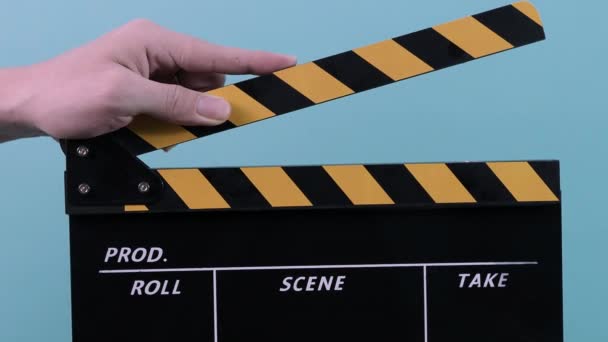 Clapperboard 사람의 클로즈업하여 검은색과 노란색 줄무늬 필름을 슬레이트를 스튜디오에서 들락날락 — 비디오
