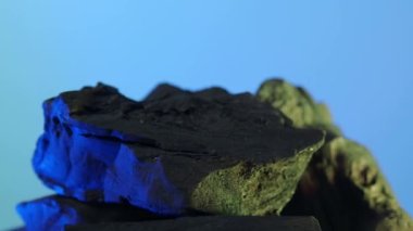 Kara Kömür. Doğal ahşap ya da mavi arka planda geleneksel kömür hareket döngüsü. Statik kamerayla çekilmiş. Mavi ve yeşil LED ışıklandırmalı 4K. Mangalda mangal kömürü. yiyecek konsepti.