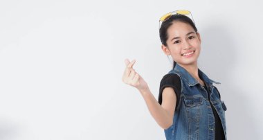 Hareketli poz. Beyaz arka plandaki Asyalı genç kadın neşeli ve kendine güvenen hareketler gösteriyor. Mini kalp gibi Tamam başparmak yukarı ya da işaret. Çok mutlu. Heyecanlı ve şaşırmış. Ceket kotu.. 