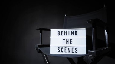 Işıkkutusu ya da Sinema Işığı kutusundaki posta panosu metni. Film tahtası ve yönetmen koltuğu. Arkaplan siyah rengi. Video yapım stüdyosunda kamera çekimi.