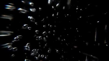 Su kabarcıkları. Su altında ve siyah arka planda tünel görüşlü makro lens. Yavaş hareket eden hava kabarcıkları suyun altında yüzüyor ve sıçrıyor. Köpük ve taze gazozu temsil eder.