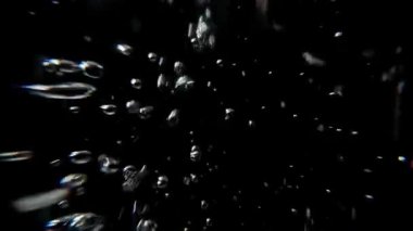 Su kabarcıkları. Su altında ve siyah arka planda tünel görüşlü makro lens. Yavaş hareket eden hava kabarcıkları suyun altında yüzüyor ve sıçrıyor. Köpük ve taze gazozu temsil eder.