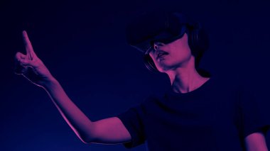 VR kulaklık takan elleri havada bir kız. Sanal gerçeklik gözlüklü Asyalı kadın. Fütürist kavramı. Dijital VR gözlükleri. Modern siyah VR kullanan kadın siber deneyim kazanıyor.