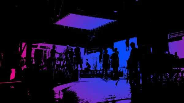 Video production behind the scenes or the making of movie and film crew team working in silhouette of camera and equipment set in studio. Online video shooting process. film industry concept.