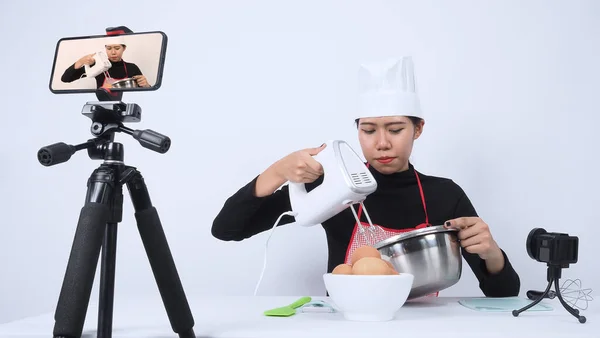 Food blogger streaming live. Online food instructor woman chef. Cooking with subscribers through phone camera online. vlogger and online influencer recording video content on healthy food.