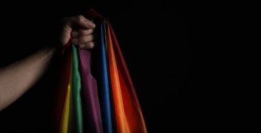 Gurur bayrağı. LGBTQ bayrağı ve el. Lezbiyen Gay Biseksüel Cinsiyet Değiştiren Gay ya da Eşcinsel Gurur Gökkuşağı bayrağı. Siyah arka plan. Özgürlük eşitliğinin el sembolünü temsil et.