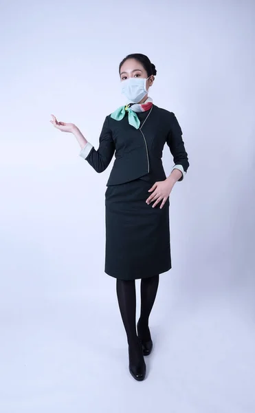 Cabin crew or air hostess with face mask in Covid 19 pandemic. Flight attendant wear medical mask to prevent coronavirus infection. New normal lifestyle in airline business. Pretty stewardess woman.