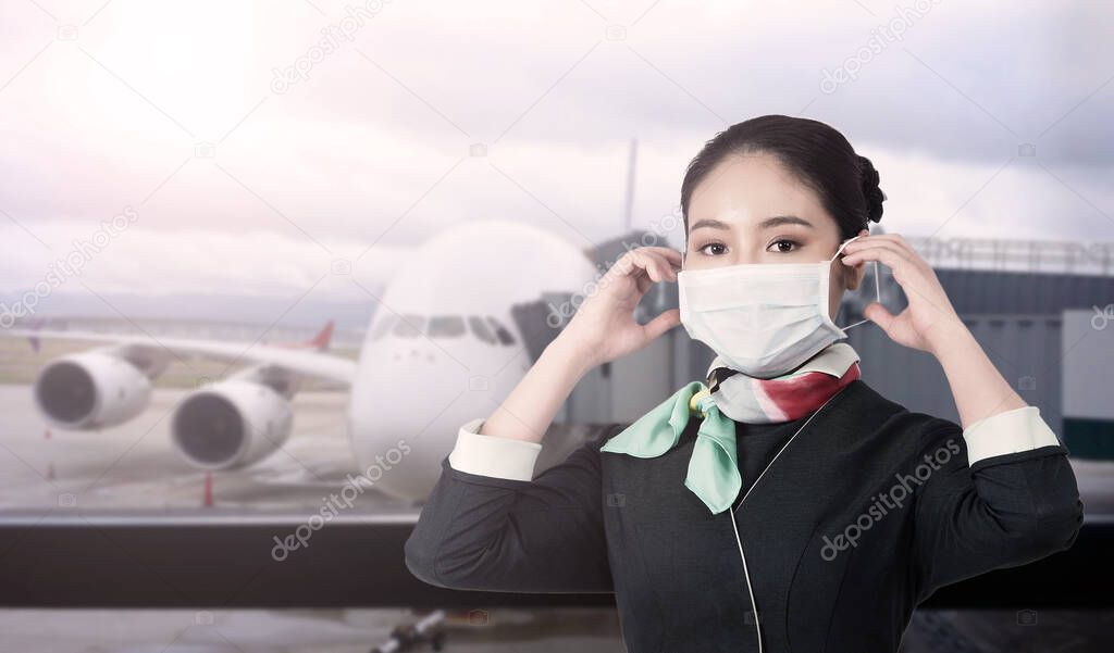 Cabin crew or air hostess with face mask in Covid 19 pandemic. Flight attendant wear medical mask to prevent coronavirus infection. New normal lifestyle in airline business. Pretty stewardess woman.