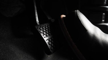 Close up the foot pressing foot pedal of a car to drive. Accelerator and brake pedal in a car. Driver driving the car by pushing accelerator and break pedals of the car. inside vehicle. control pedal.