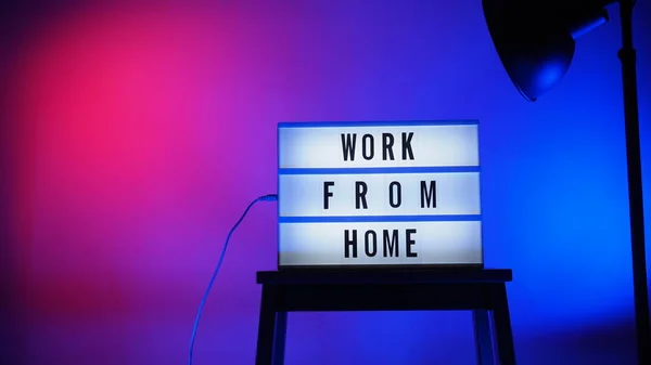Work from home light box in studio. WFH Text on lightbox. Represent work from home for social distancing concept during coronavirus pandemic. WFH message on light board COVID 19 quarantine situation